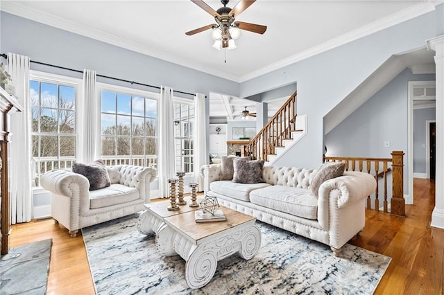living room with wood finished floors, a ceiling fan, and ornamental molding