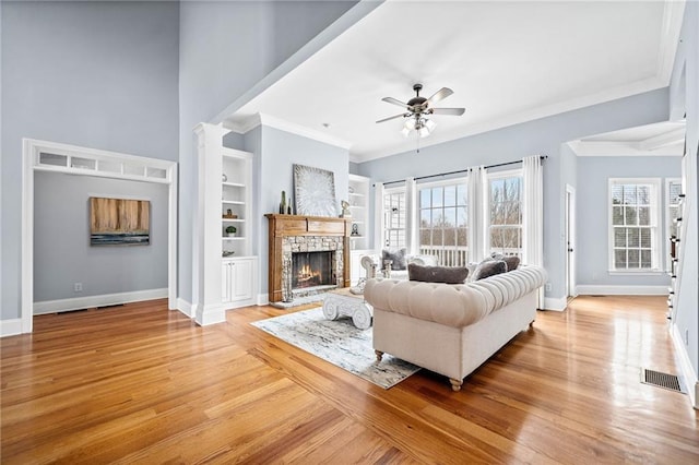 living room with light wood-style floors, plenty of natural light, and a ceiling fan