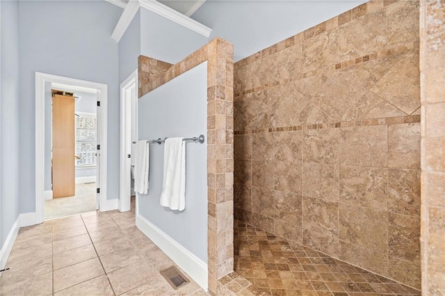 bathroom featuring tile patterned floors, visible vents, crown molding, baseboards, and walk in shower