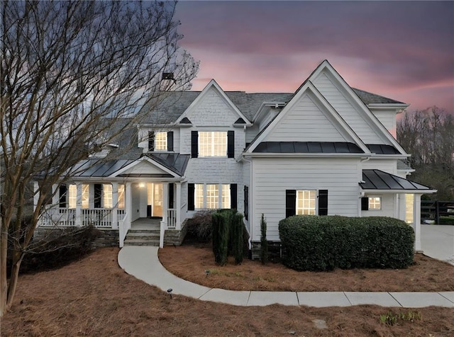 view of front of house featuring a standing seam roof, a porch, and metal roof