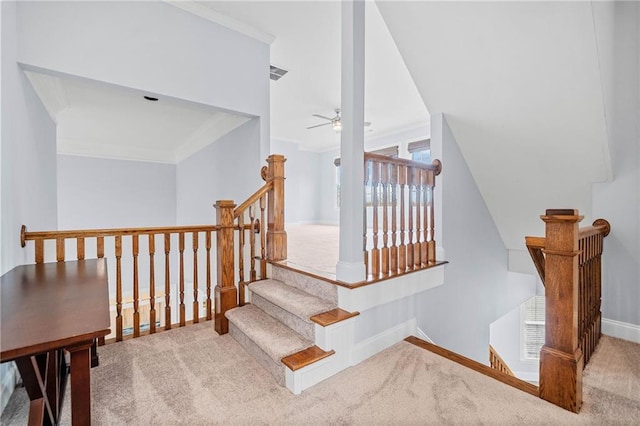 staircase with visible vents, ornamental molding, carpet floors, baseboards, and ceiling fan