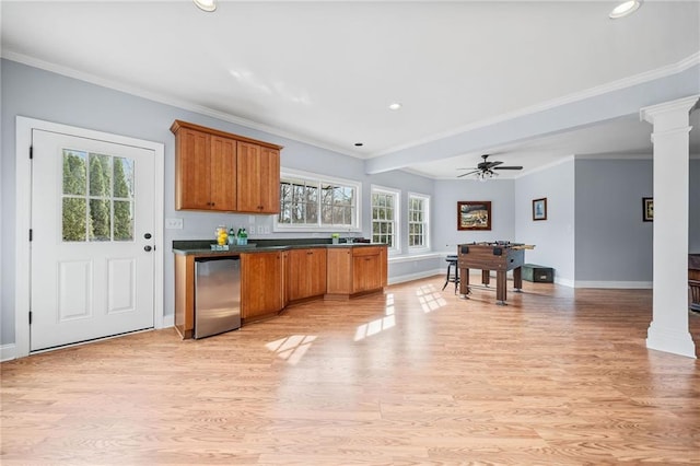 kitchen featuring baseboards, brown cabinets, ornate columns, and fridge