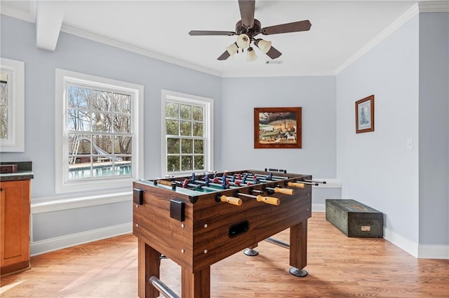 playroom with ceiling fan, baseboards, ornamental molding, and light wood-style flooring