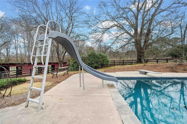 view of pool featuring a fenced backyard, a water slide, a diving board, and a fenced in pool