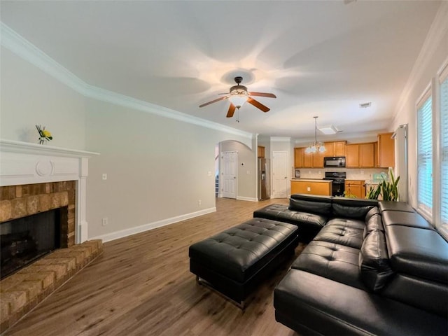 750 Summerstone Ln, Lawrenceville, GA 30044 - living area featuring a ceiling fan, crown molding, baseboards, light wood-type flooring, and arched walkways