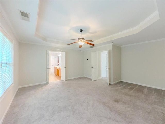 750 Summerstone Ln, Lawrenceville, GA 30044 - unfurnished living room featuring a raised ceiling, arched walkways, light colored carpet, ceiling fan, and ornamental molding