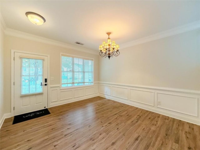 750 Summerstone Ln, Lawrenceville, GA 30044 - foyer with a chandelier, crown molding, wood finished floors, healthy amount of natural light, and wainscoting