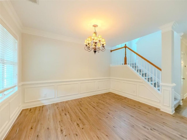 750 Summerstone Ln, Lawrenceville, GA 30044 - spare room with a chandelier, crown molding, stairs, a decorative wall, and light wood-type flooring