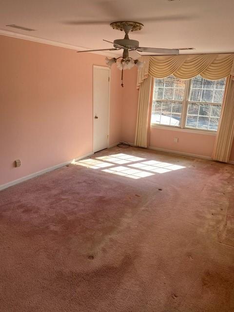 carpeted spare room with crown molding and ceiling fan