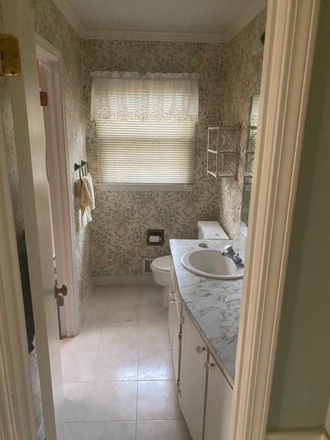 bathroom featuring vanity, crown molding, tile patterned floors, and toilet