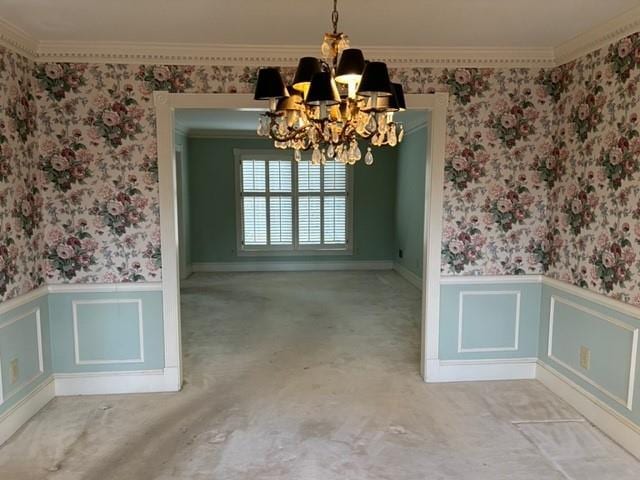 unfurnished dining area featuring crown molding and a chandelier