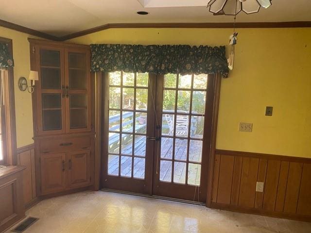 doorway to outside with vaulted ceiling, ornamental molding, and french doors