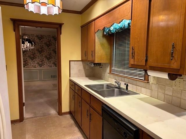 kitchen with crown molding, dishwasher, sink, and decorative backsplash