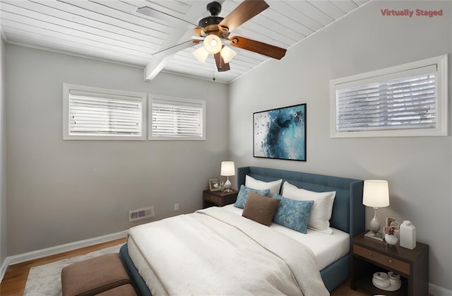 bedroom featuring beamed ceiling, ceiling fan, wood ceiling, and hardwood / wood-style floors