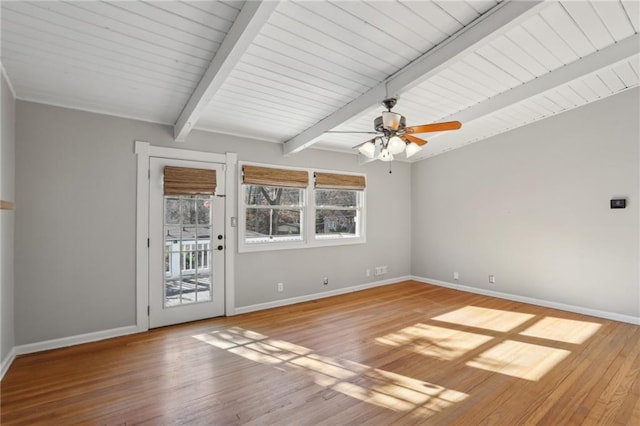 unfurnished room featuring plenty of natural light, beam ceiling, and light hardwood / wood-style flooring