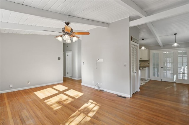 empty room featuring vaulted ceiling with beams, hardwood / wood-style floors, and ceiling fan