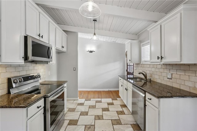 kitchen featuring stainless steel appliances, white cabinetry, beamed ceiling, and decorative light fixtures