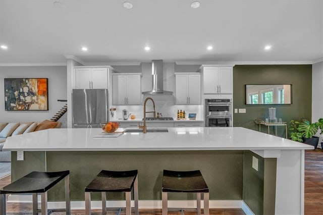 2066 Patterson Park Rd, Decatur, GA 30033 - kitchen featuring stainless steel appliances, wall chimney exhaust hood, a large island with sink, recessed lighting, and light countertops