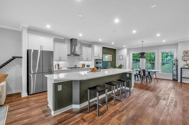2066 Patterson Park Rd, Decatur, GA 30033 - kitchen featuring freestanding refrigerator, wall chimney range hood, ornamental molding, a large island with sink, and gas stovetop