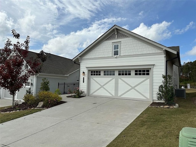 view of front of property with central AC unit, a front yard, and a garage