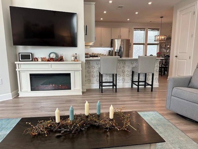 living room featuring a chandelier and light wood-type flooring