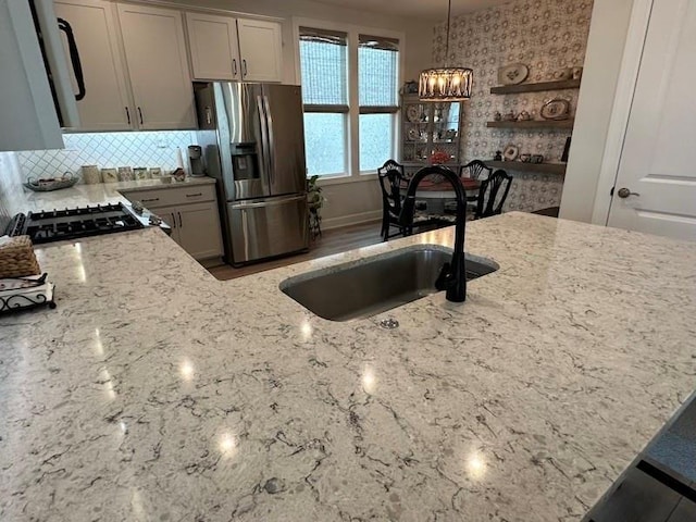 kitchen featuring range, sink, hanging light fixtures, gray cabinets, and stainless steel fridge with ice dispenser