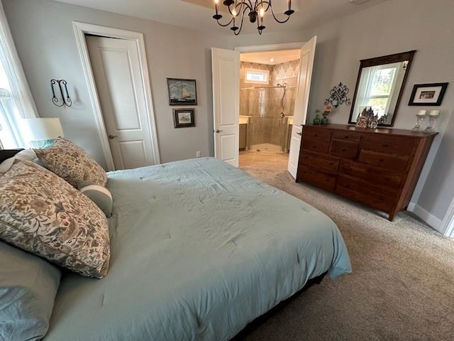 bedroom featuring connected bathroom, a closet, light colored carpet, and an inviting chandelier