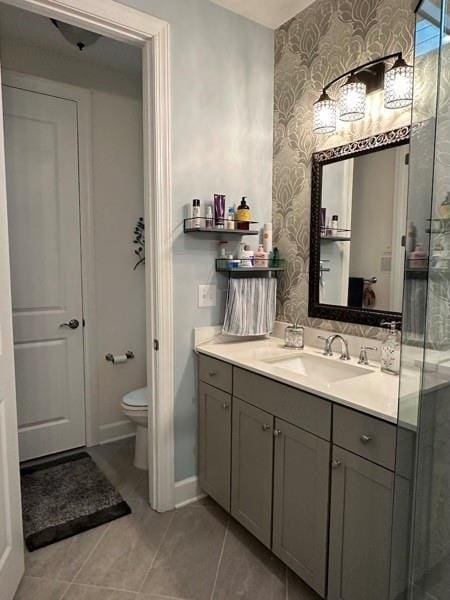 bathroom with tile patterned flooring, vanity, and toilet