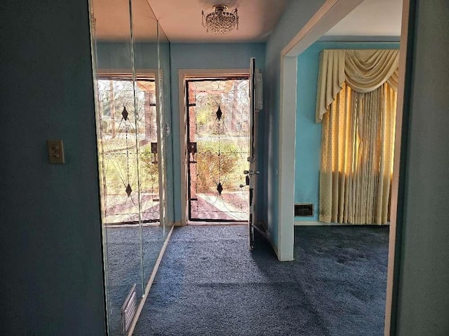 doorway with dark colored carpet