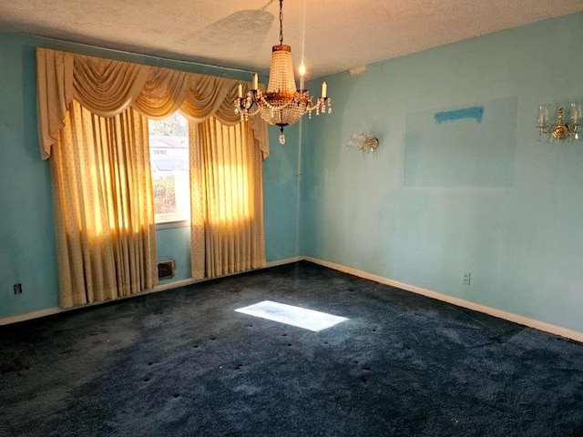 carpeted empty room featuring a notable chandelier and a textured ceiling