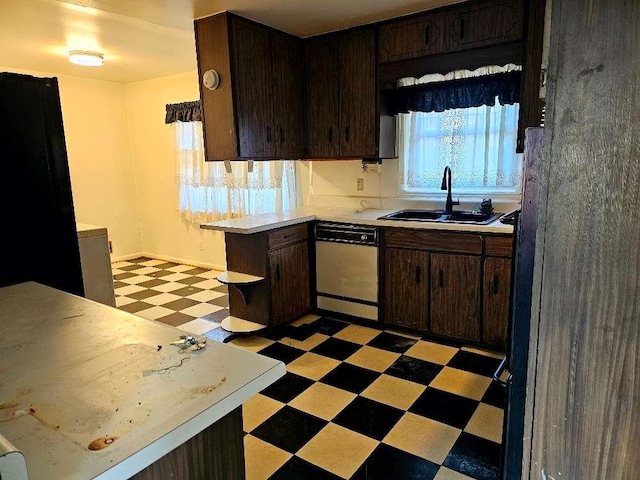 kitchen with dark brown cabinets, sink, and dishwashing machine