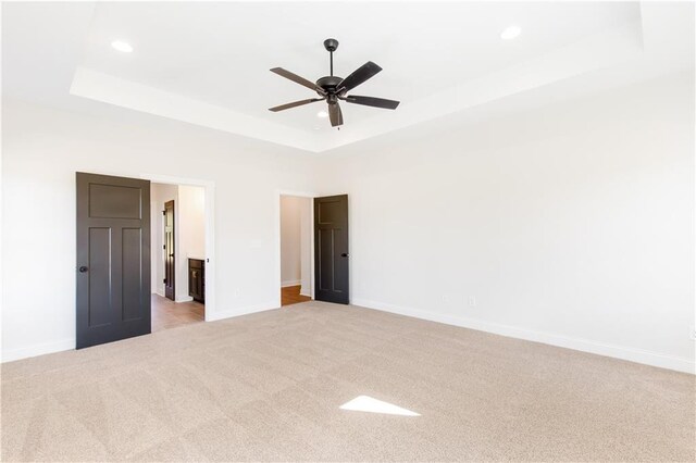 102 Red Oak Ln, Carrollton, GA 30116 - unfurnished bedroom featuring a tray ceiling, light carpet, recessed lighting, a ceiling fan, and ensuite bathroom