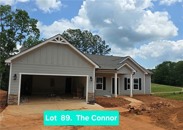 8970 Callaway Dr, Winston, GA 30187 - view of front facade featuring board and batten siding, a garage, stone siding, covered porch, and driveway