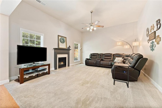 525 Roland Manor Dr, Dacula, GA 30019 - living area featuring a ceiling fan, baseboards, a fireplace with flush hearth, and carpet floors