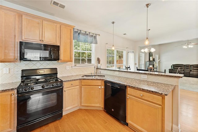 525 Roland Manor Dr, Dacula, GA 30019 - kitchen with black appliances, a peninsula, light wood finished floors, a sink, and tasteful backsplash