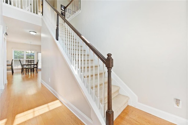 525 Roland Manor Dr, Dacula, GA 30019 - stairs with wood-type flooring, baseboards, and a chandelier