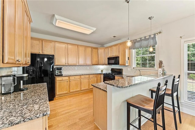 525 Roland Manor Dr, Dacula, GA 30019 - kitchen featuring black appliances, a sink, a peninsula, and light brown cabinets