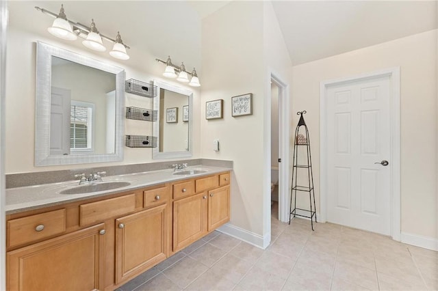 525 Roland Manor Dr, Dacula, GA 30019 - full bath with vaulted ceiling, double vanity, tile patterned flooring, baseboards, and toilet