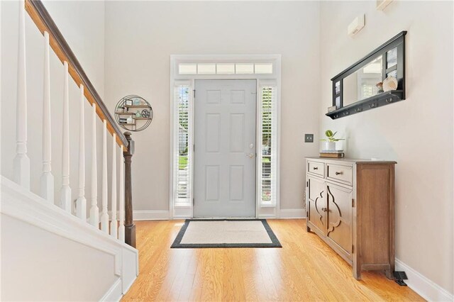525 Roland Manor Dr, Dacula, GA 30019 - entrance foyer featuring light wood-type flooring, stairs, a towering ceiling, and baseboards