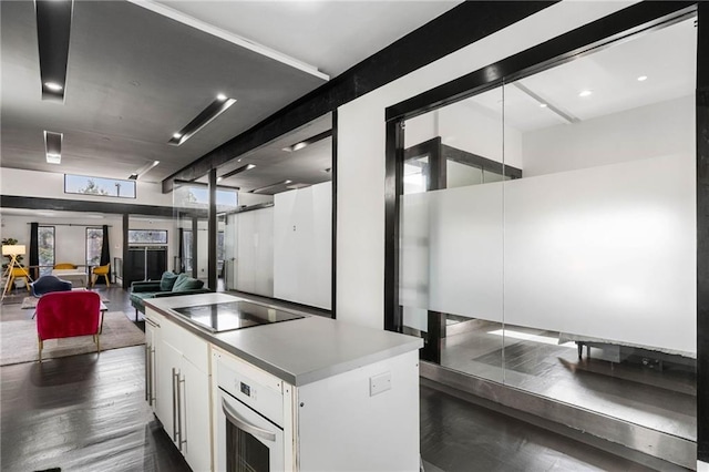 kitchen featuring black electric cooktop, white cabinetry, oven, and a kitchen island