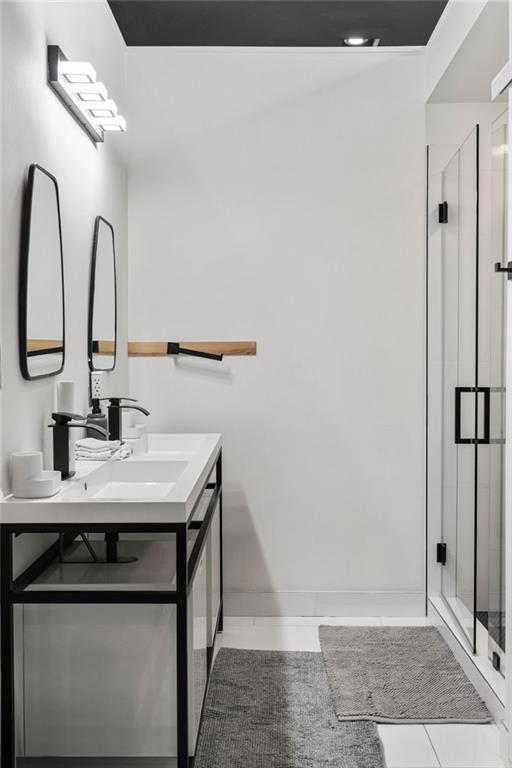 bathroom featuring tile patterned flooring, vanity, and walk in shower