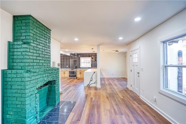 living room with wood-type flooring, a fireplace, and beverage cooler