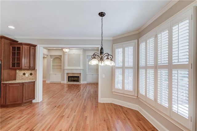 255 Beech Tree Holw, Sugar Hill, GA 30518 - unfurnished dining area featuring light wood-style floors, a chandelier, a fireplace, ornamental molding, and baseboards