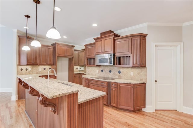 255 Beech Tree Holw, Sugar Hill, GA 30518 - kitchen featuring stainless steel microwave, a sink, brown cabinets, light wood finished floors, and crown molding