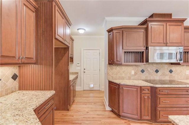 255 Beech Tree Holw, Sugar Hill, GA 30518 - kitchen with stainless steel microwave, black electric cooktop, light wood-style floors, light stone counters, and ornamental molding