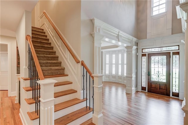 255 Beech Tree Holw, Sugar Hill, GA 30518 - entrance foyer with light wood-style floors, a high ceiling, stairs, and decorative columns