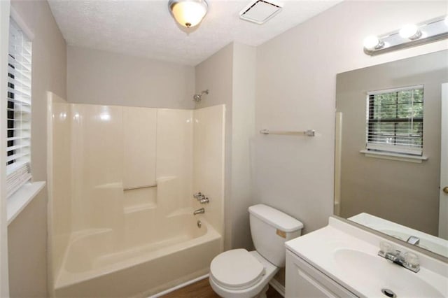 full bathroom with wood-type flooring, shower / bath combination, a textured ceiling, toilet, and vanity