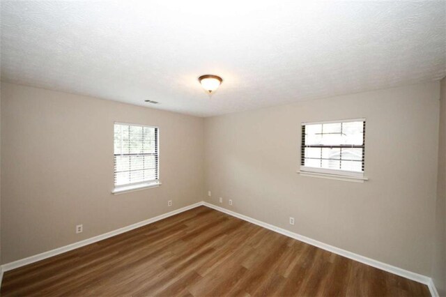 unfurnished room featuring dark wood-type flooring