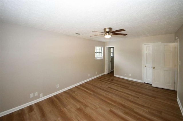 spare room with ceiling fan, dark hardwood / wood-style flooring, and a textured ceiling