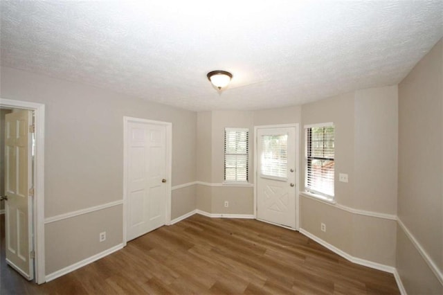 interior space featuring wood-type flooring and a textured ceiling